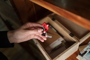 Close-up of a hand holding a vintage hockey toy from a wooden box.