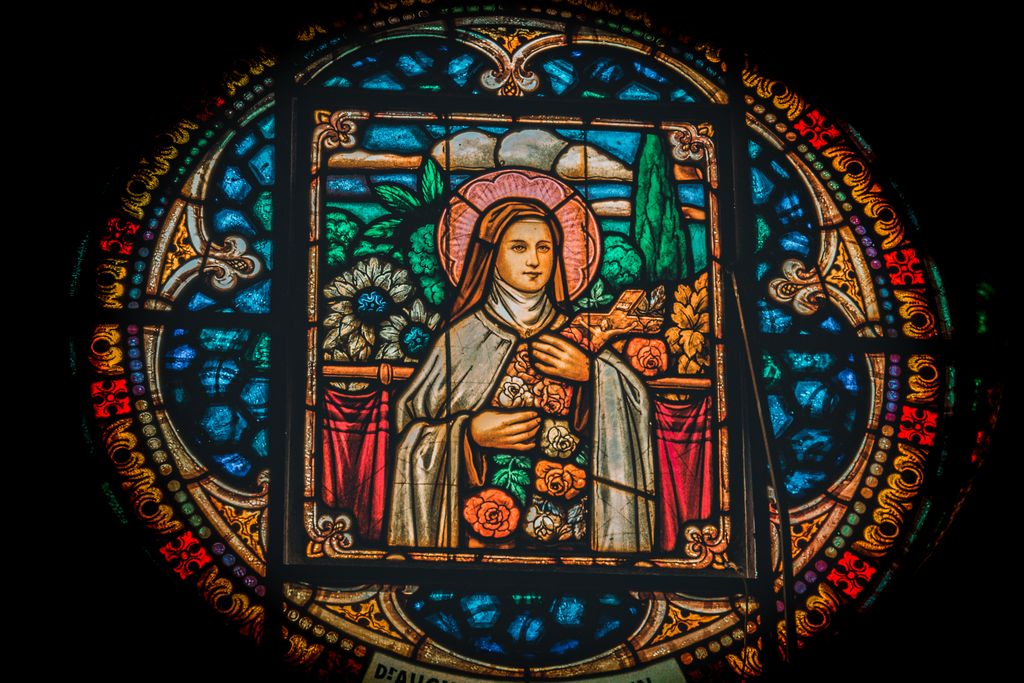 Detailed stained glass artwork featuring a religious figure with vibrant colors and intricate designs.